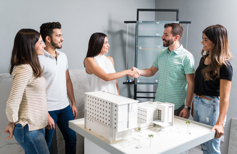 business-partners-shaking-hands-with-engineer-by-architectural-model-meeting 1