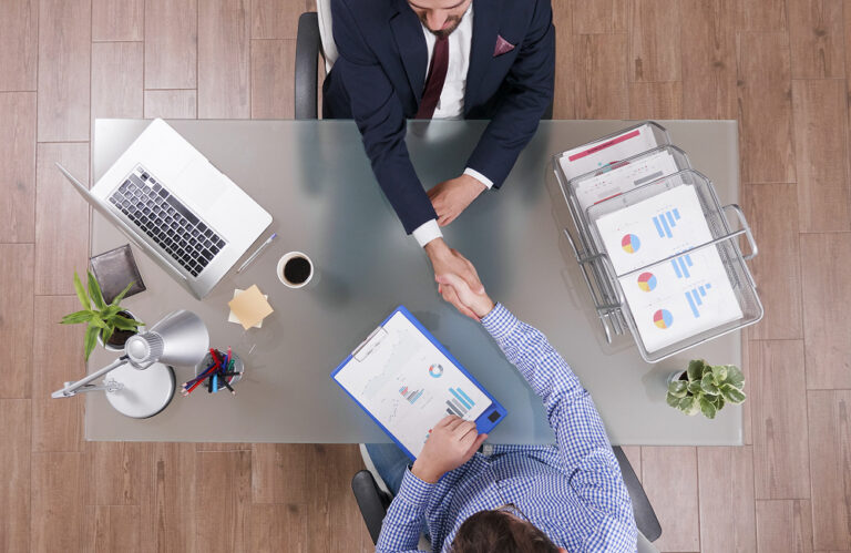 top-view-businessmen-shaking-hands-business-negotiation-startup-office 1